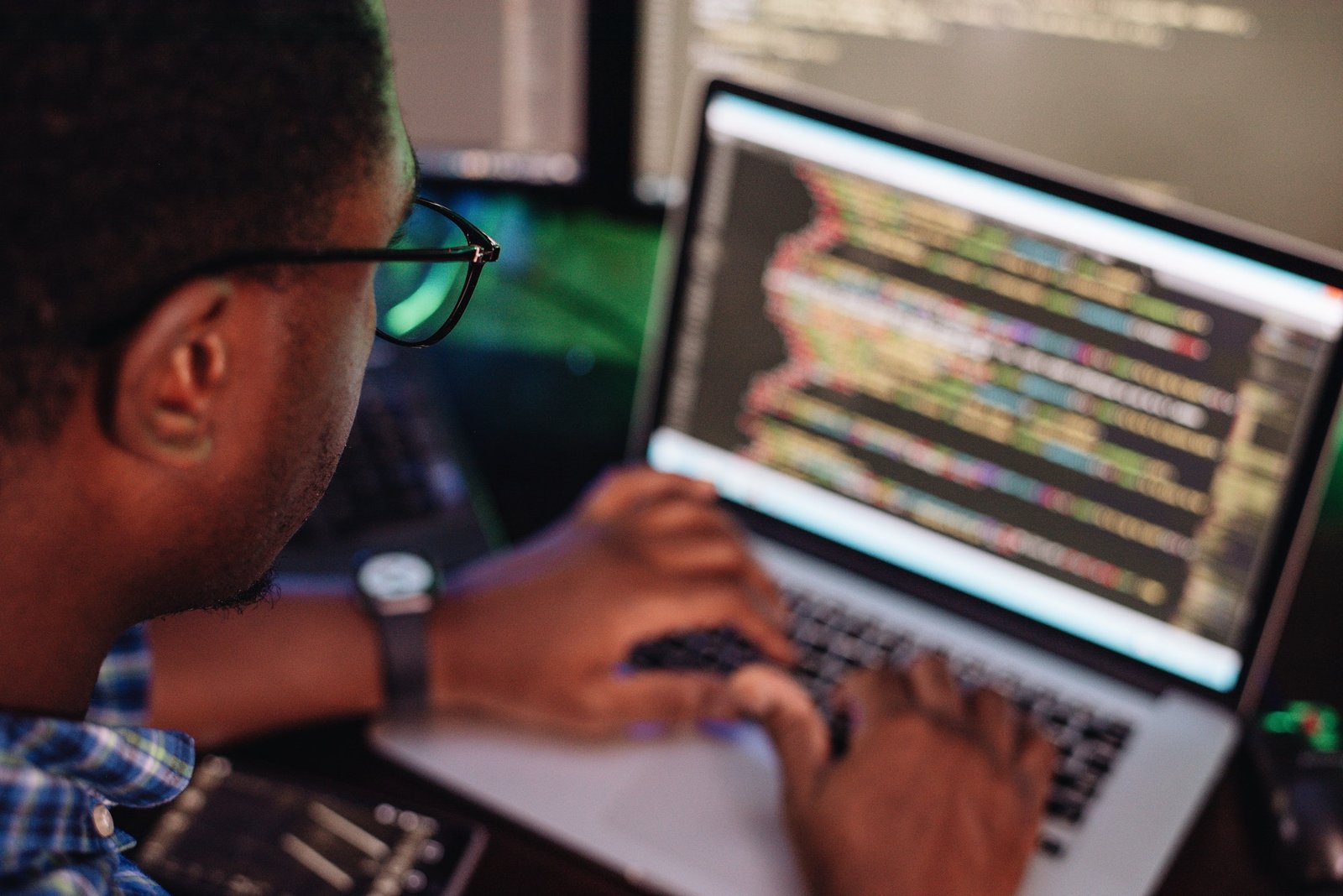 black male in front of computer screen coding mobile app web development computer programming 1
